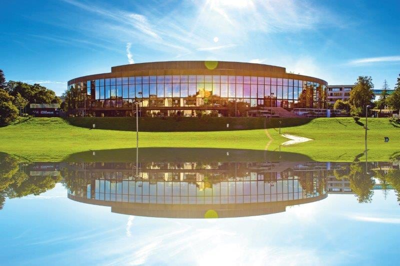 Brucknerhaus Linz mit Spiegelung im Wasser bei Sonnenschein