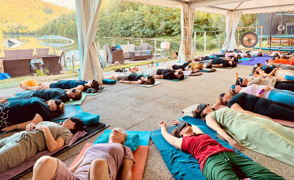 Gruppe liegt mit Augenmasken während der Atemfitness Reise am Salmsee