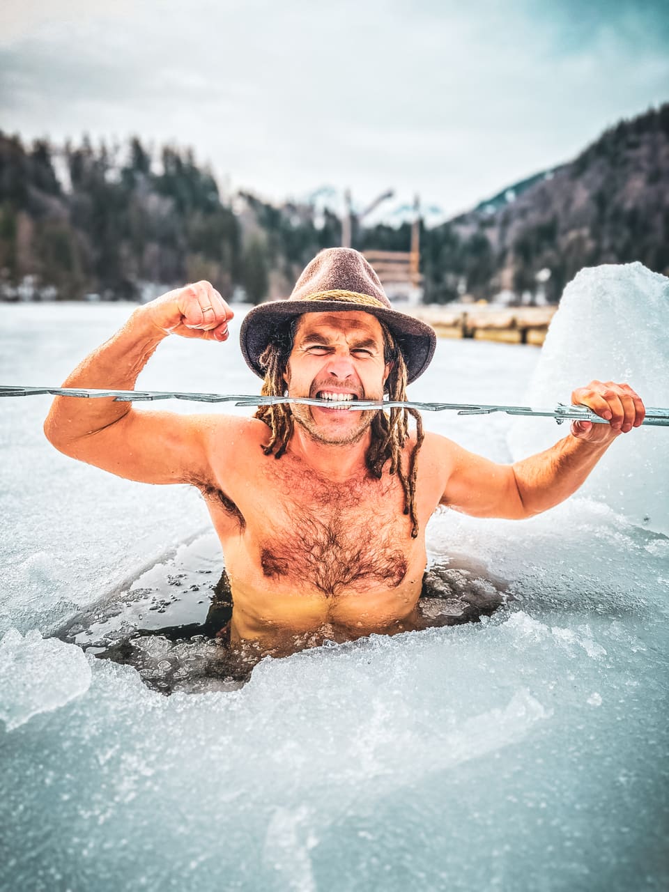 Daniel Fetzy Fetz beißt in einem Eisloch spielerisch auf eine Eissäge