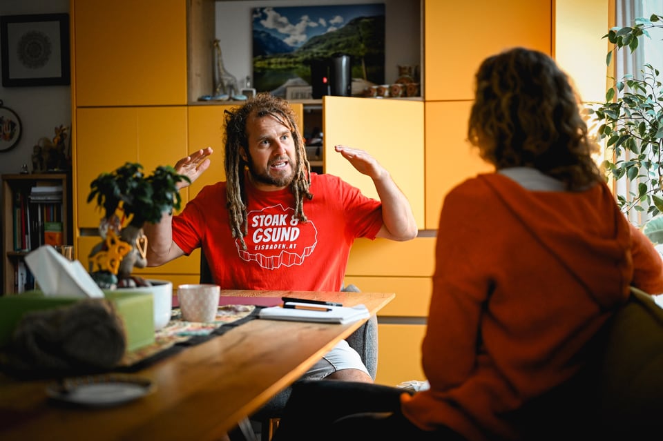 Daniel Fetz erklärt einer Gesprächspartnerin Atemfitness an einem Tisch