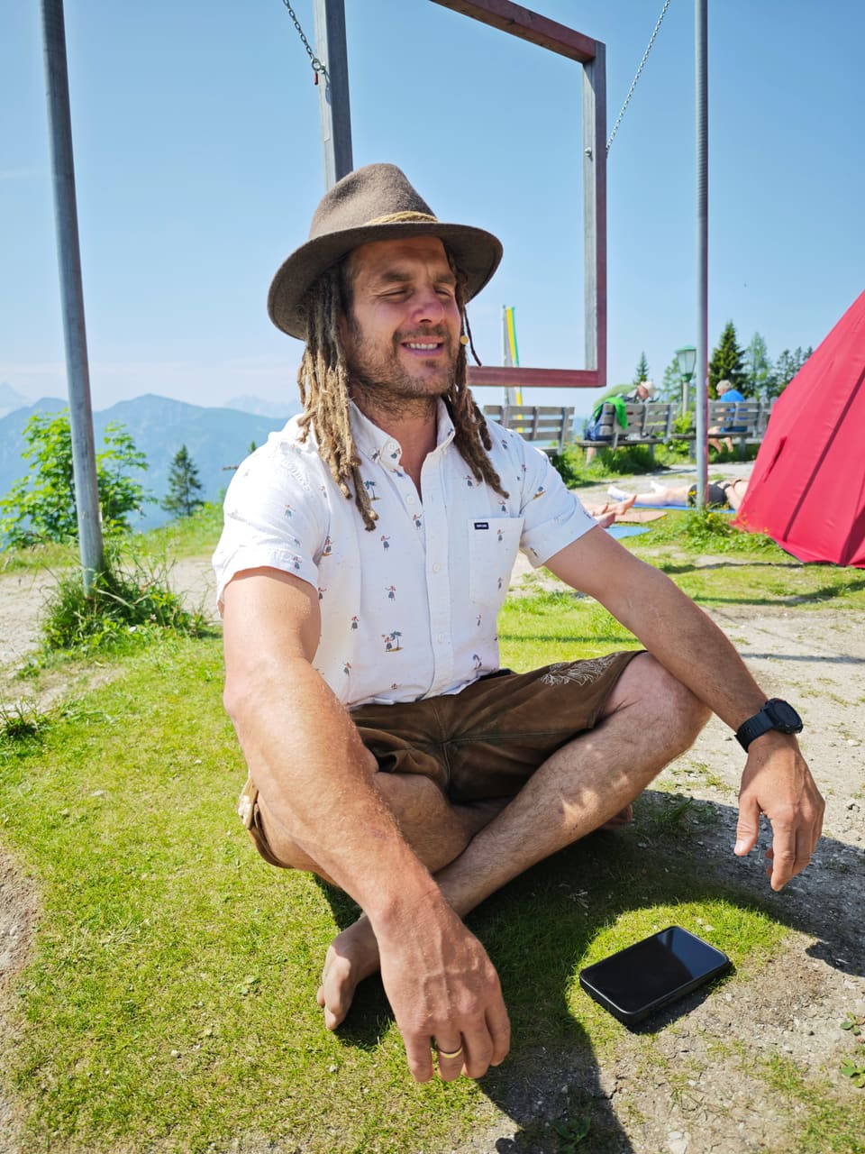 Daniel Fetzy Fetz sitzt entspannt vor einem Bergpanorama