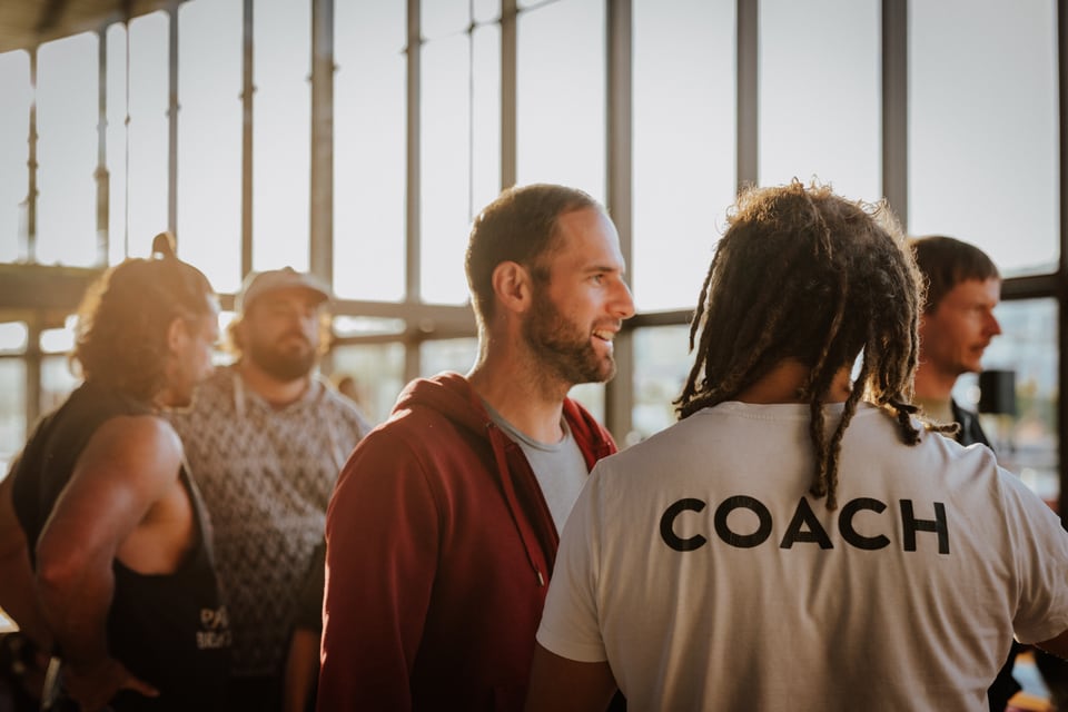 Teilnehmende im Gespräch mit einem Coach im sonnigen Brucknerhaus