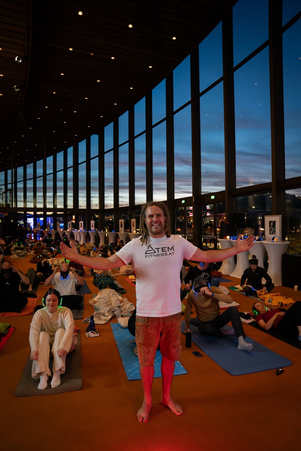 Fetzy steht mit geöffneten Armen im abendlichen Foyer