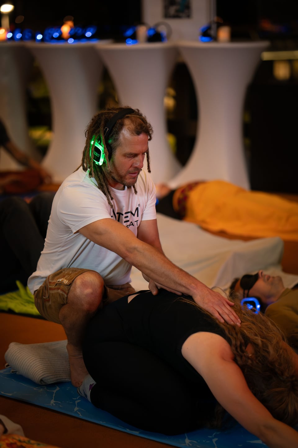 Fetzy legt einer nach vorne gebeugten Teilnehmerin eine Hand auf den Rücken