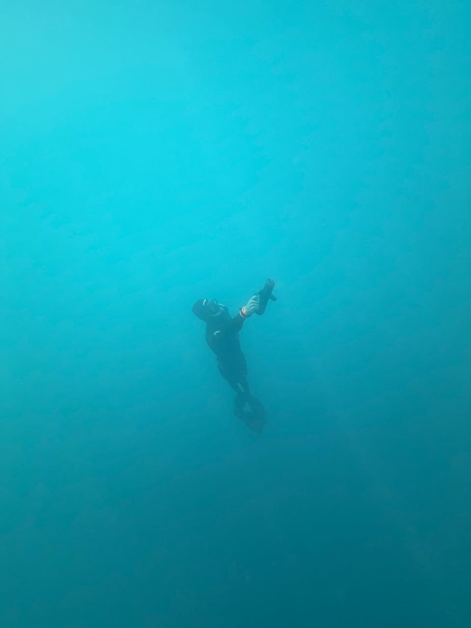Freitaucher mit geöffneten Armen unter Wasser