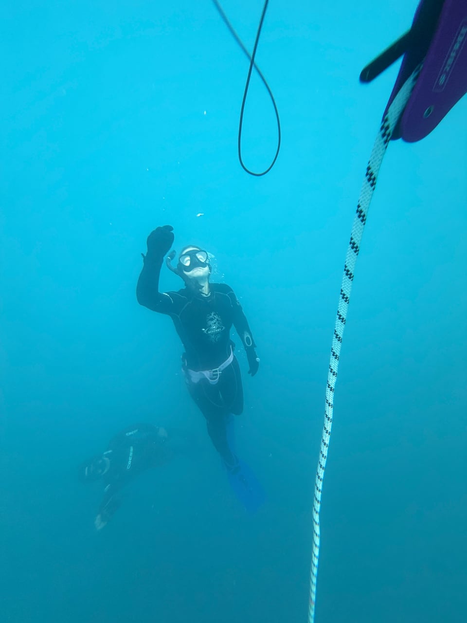 Freitaucher neben dem Führungsseil unter Wasser