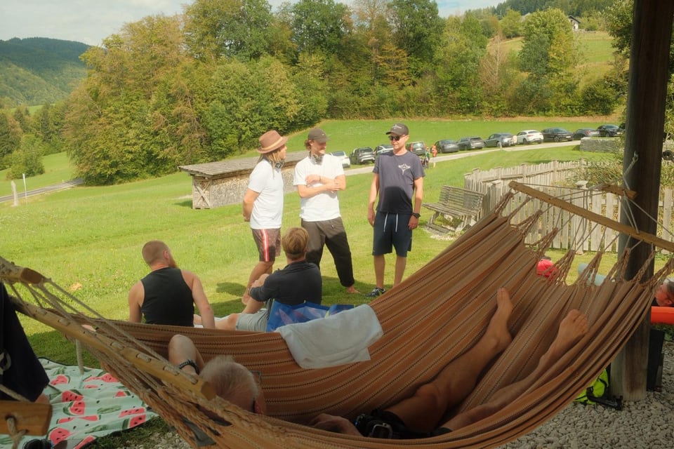 Teilnehmende entspannen bei einer Hängematte auf der Wiese