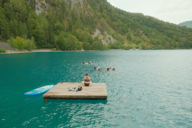 Schwimmplattform und Gruppe im türkisfarbenen Wasser am Attersee