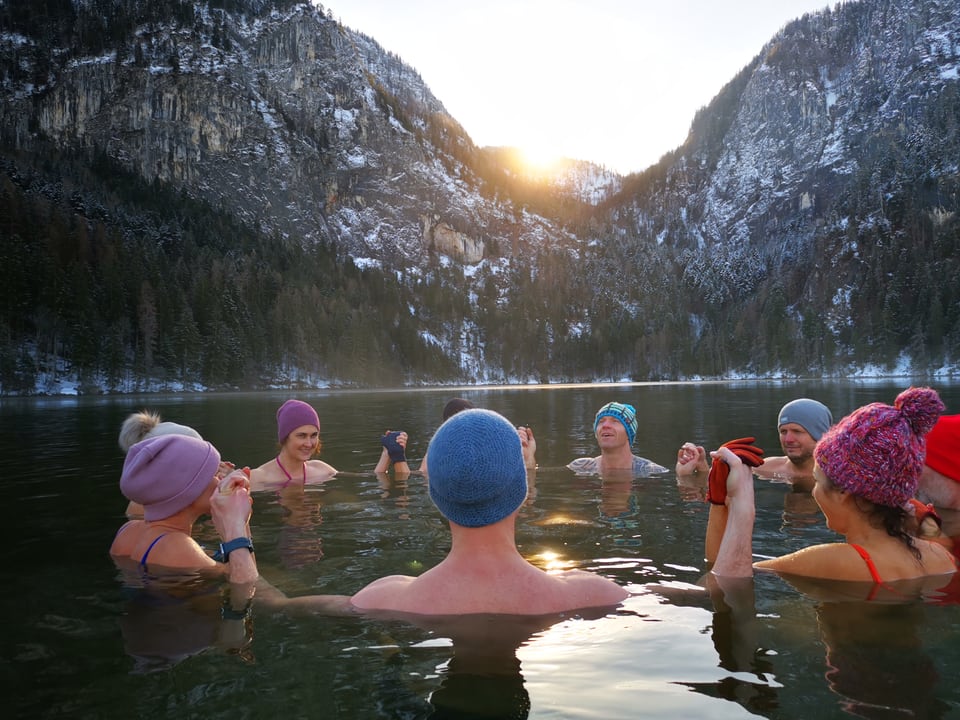 Retreatgruppe badet bei tief stehender Sonne im winterlichen Gleinkersee