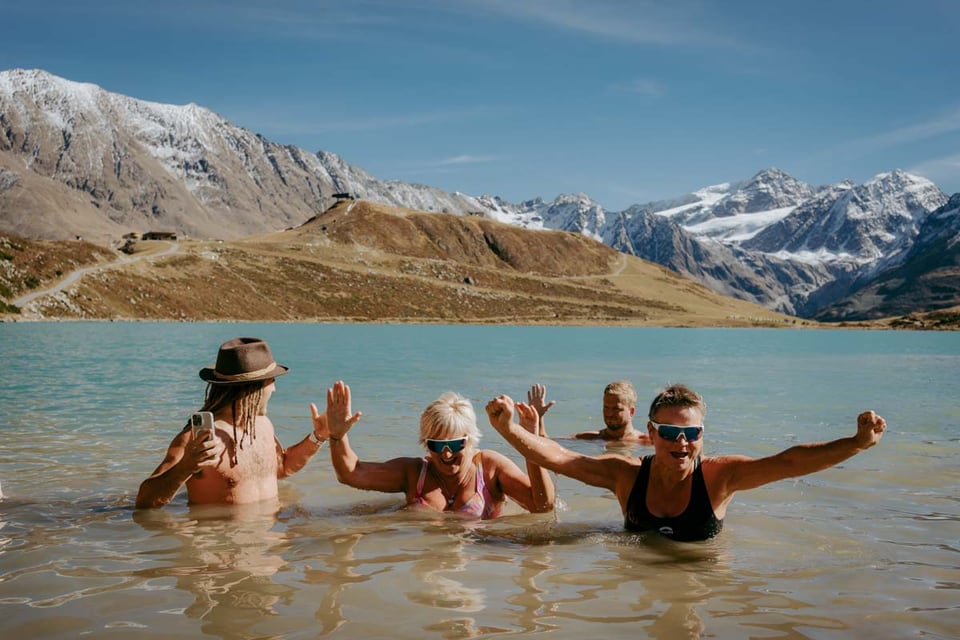 Retreatgruppe steigt jubelnd aus einem Bergsee im Pitztal