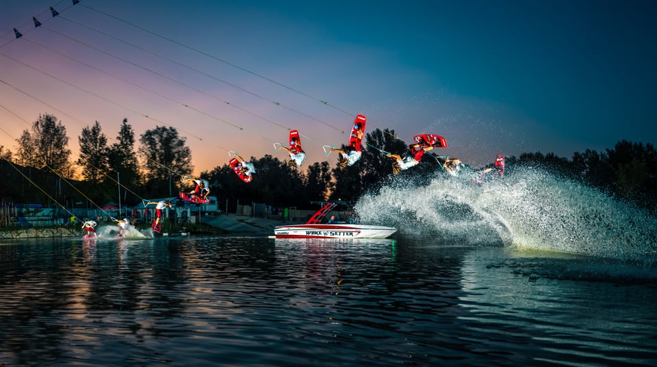 Daniel Fetz zeigt eine Wakeboard-Sequenz hinter einem Boot in der Abenddämmerung